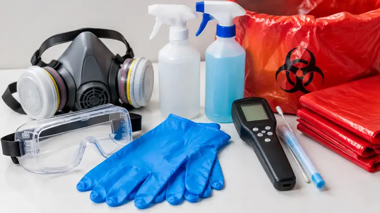 Protective equipment and cleaning supplies arranged on a table